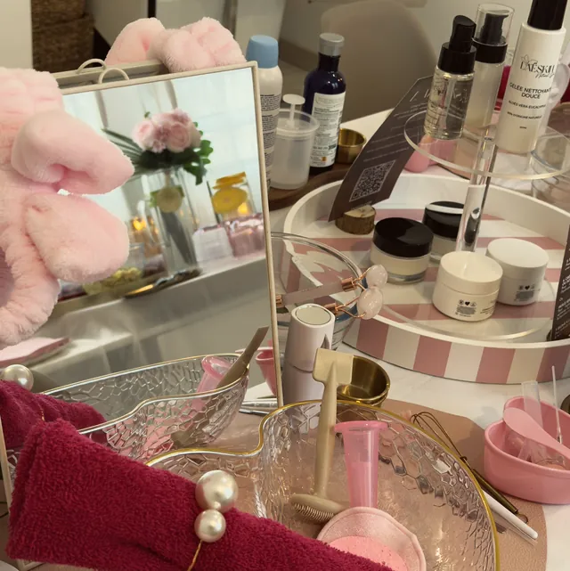 Les soins et accessoires d'un atelier, sur une table nappée de rose