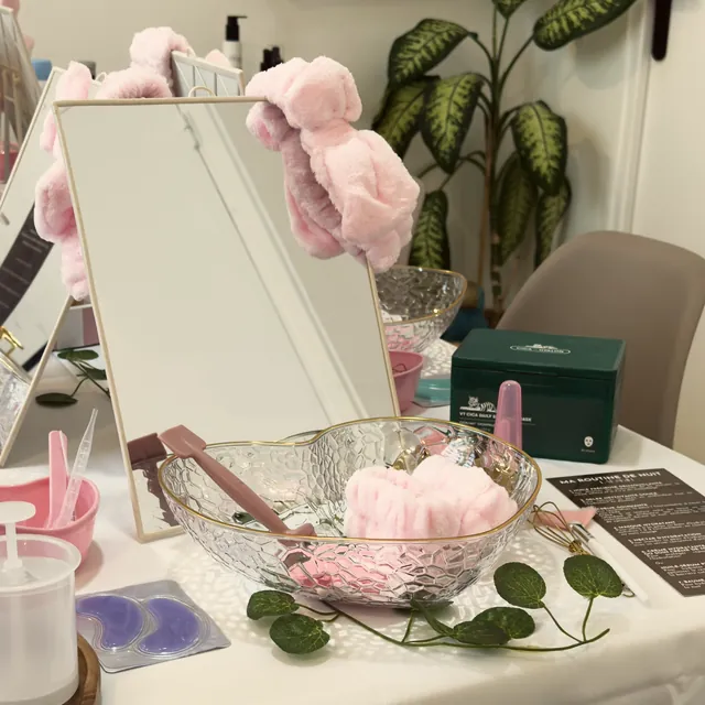 Un atelier skincare prêt : miroir, bandeaux roses et coupelles