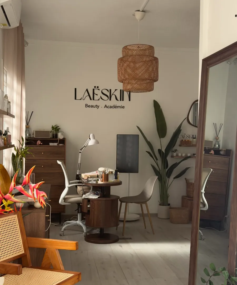 L'accueil de l'Institut Laë : l'enseigne LaëSkin Beauty · Académie, une suspension en rotin, le poste d'onglerie et des plantes
