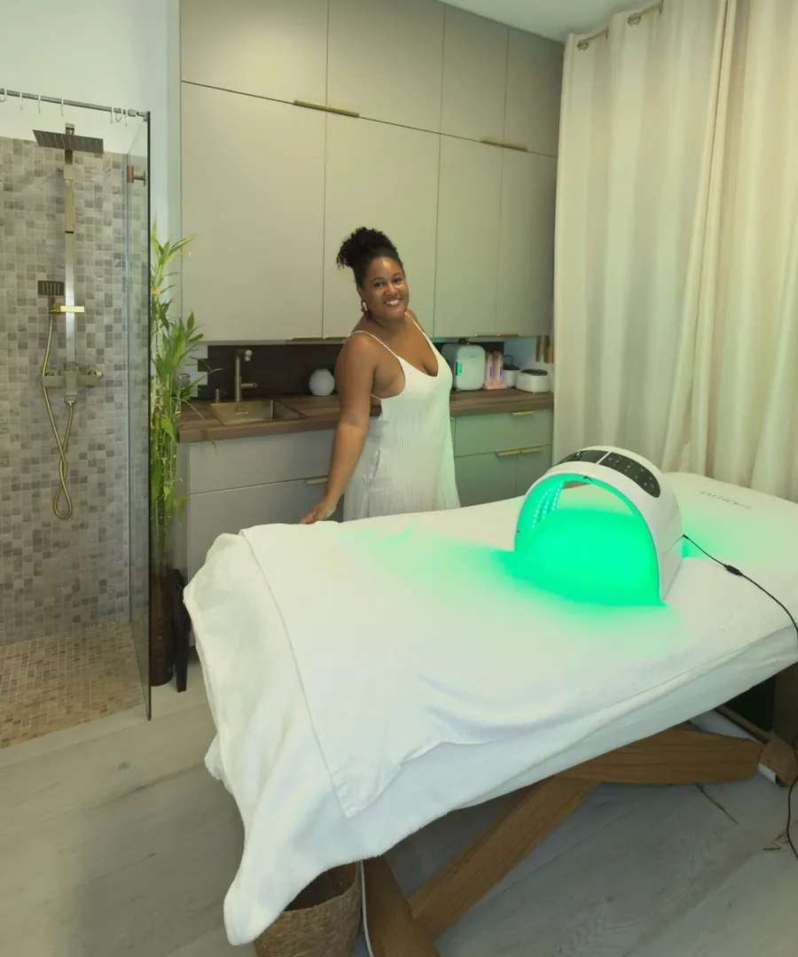 La cabine de soins, le masque LED allumé en vert, et Laëtitia derrière la table