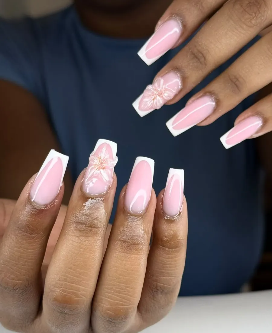 Ongles longs et carrés en french blanche sur base rose, une fleur en relief sur deux ongles